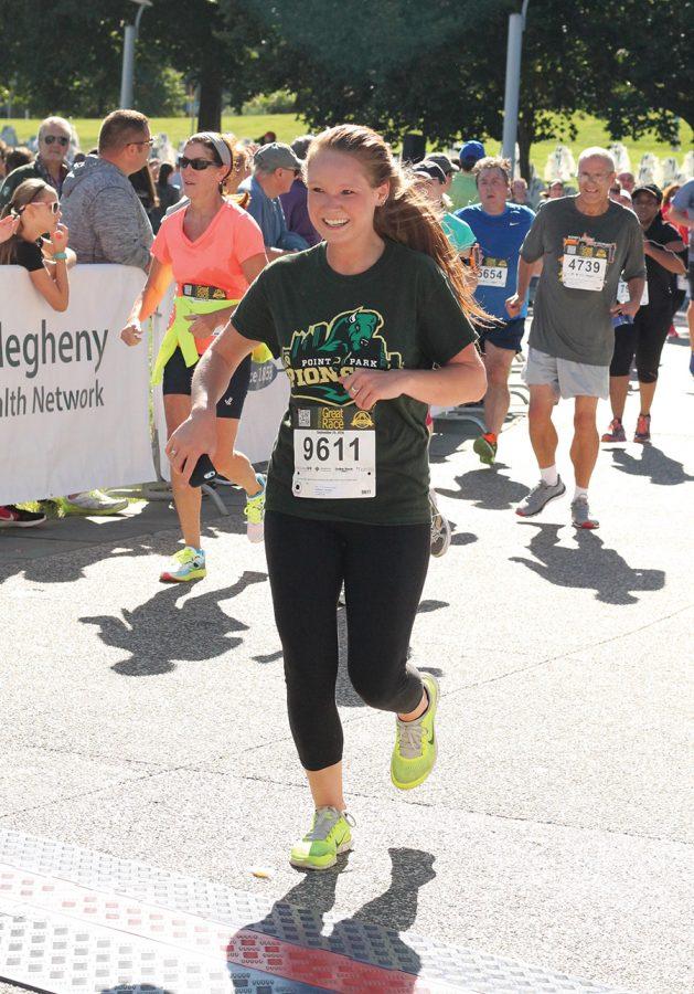 Jennifer Huffman, a 2014 graduate of the SAEM program, runs through the finish line during the Great Race Sunday. 