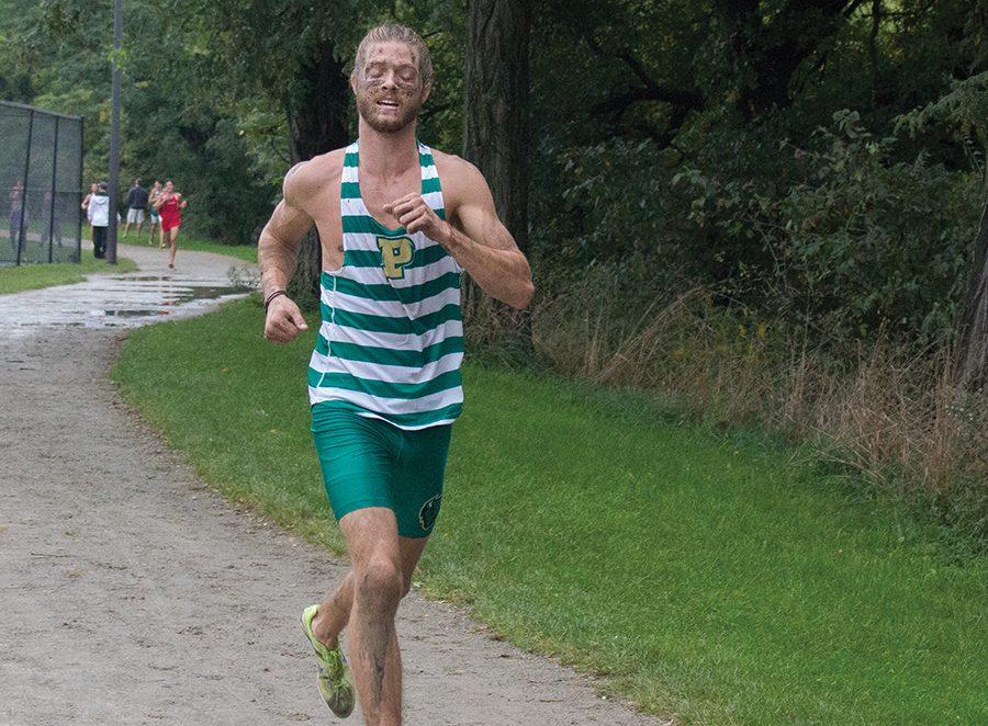 Junior Chris Hunt runs while covered in mud at the Carnegie Mellon Invitational. The men’s cross country team placed fifth of 11 teams.