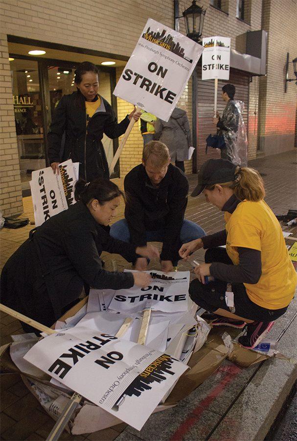 Pittsburgh Symphony musicians Irene Cheng, Lisa Gedris, and Charlie Powers making picket signs while striking outside of Heinz Hall Sept. 30.
