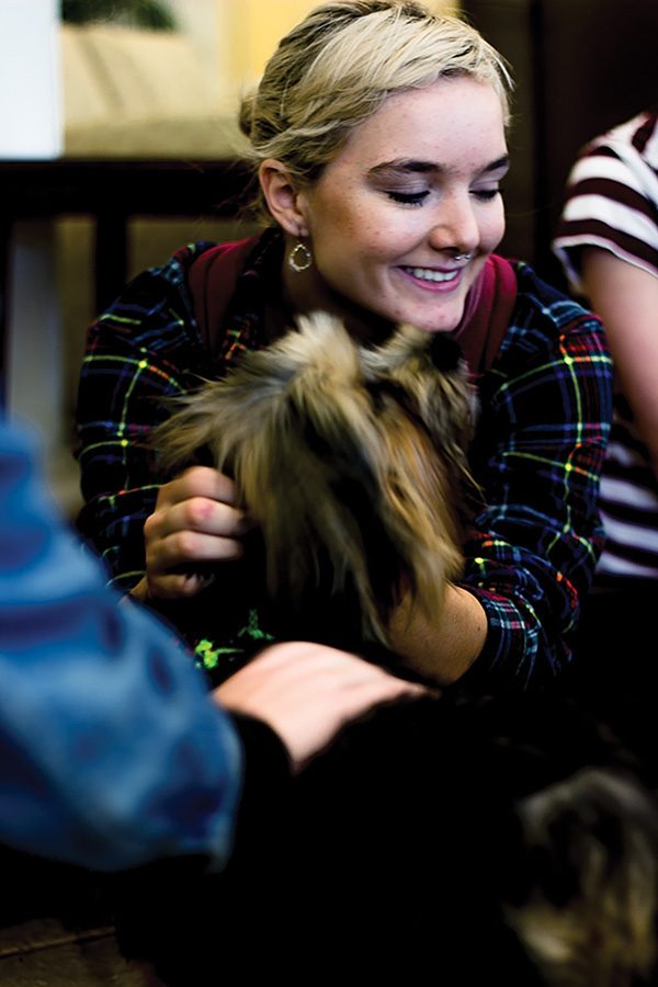 Freshman dance major, Alanna O’Brien, pets therapy dog named Mauli on Thursday during the Human Society Hug a Hound event. The event was held in the Lawrence Hall lobby. 