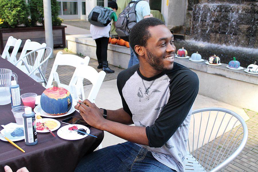 Quintin Reynolds, sophomore musical theater major, paints the famous painting “The Scream” on his pumpkin at Culinarts Apple Festival in Village Park on Wednesday, October 19. 