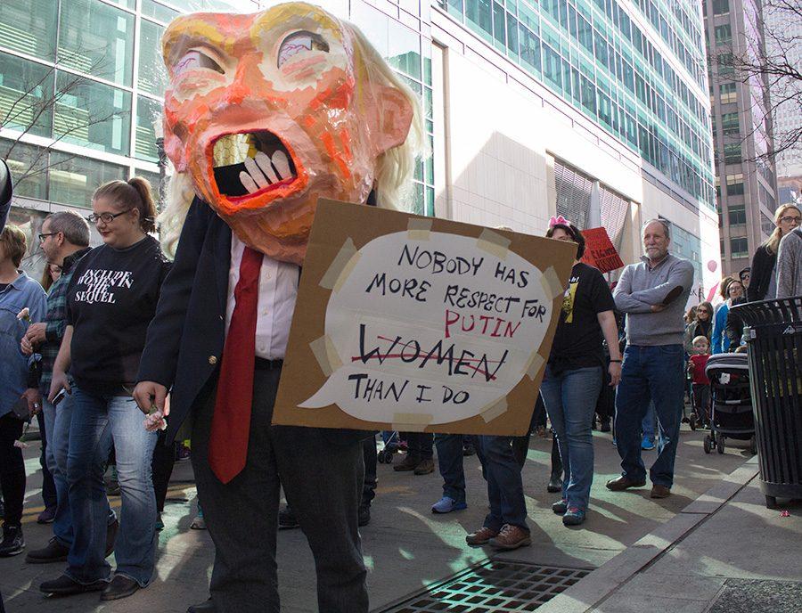 A demonstrator, wearing a paper mache Trump mask, walks along Grant Street during the Women’s March Jan. 21.