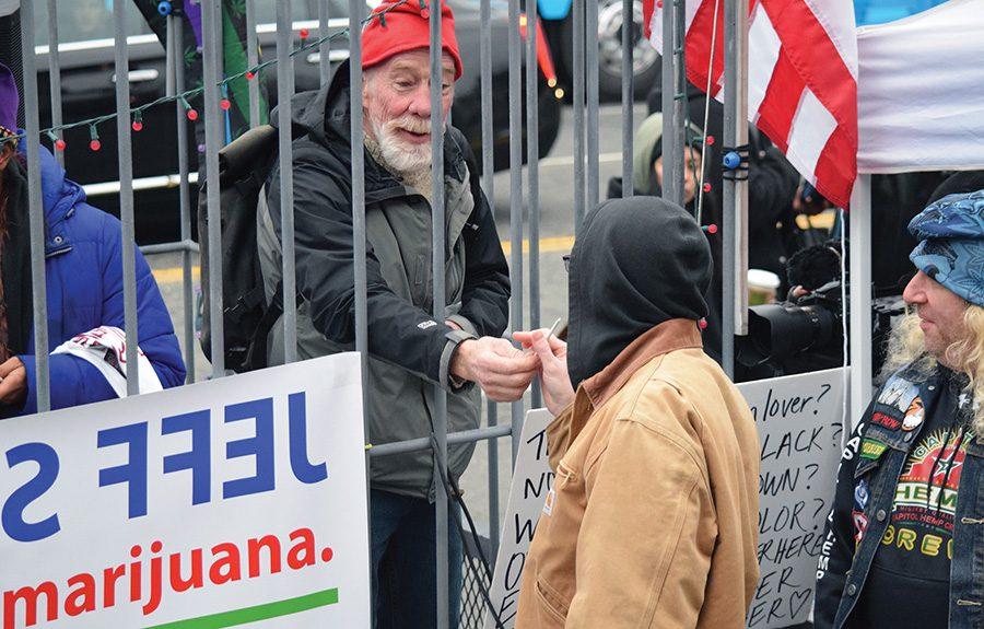 A older man hands someone a weed joint during a #Trump420 protest near Dupont Circle. He would tell people, “I wish you a long and healthy life.”