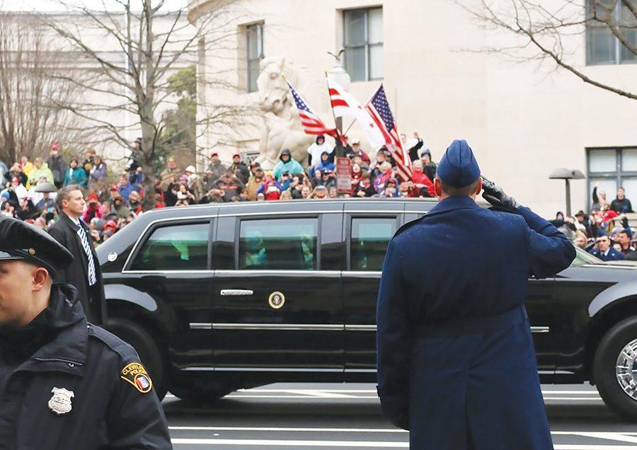 President Donald Trump waves to crowd members during the parade.