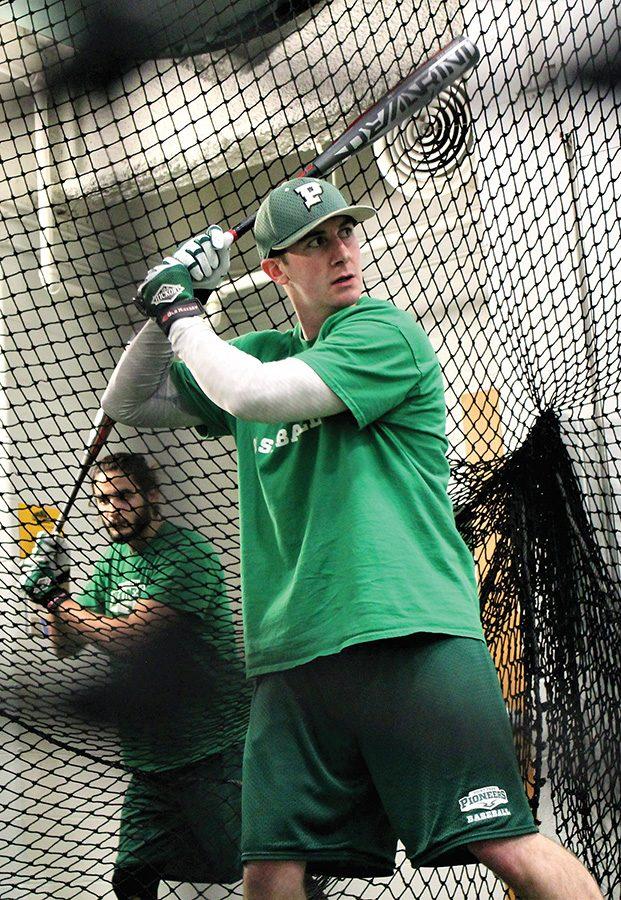 Senior, Logan Linder practices in the batting cage. 
