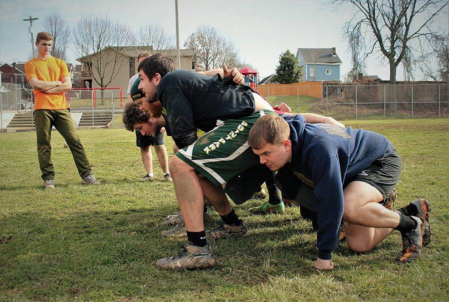 Members of the rugby team practice the formation of a scrum during their conditioning at Dan Marino Field.

