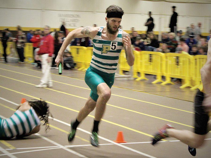 Aaron Barlow, sophomore, runs with the relay stick on Friday’s meet. The men’s indoor track and field team placed 1st of 14 teams that participated in the meet.
