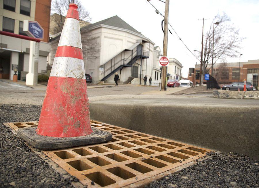 A traffic cone warns motorists of the fixed sinkhole on Hamlet Avenue in Oakland near the drop off point for Point Park shuttles at the Pittsburgh Playhouse Monday afternoon. 