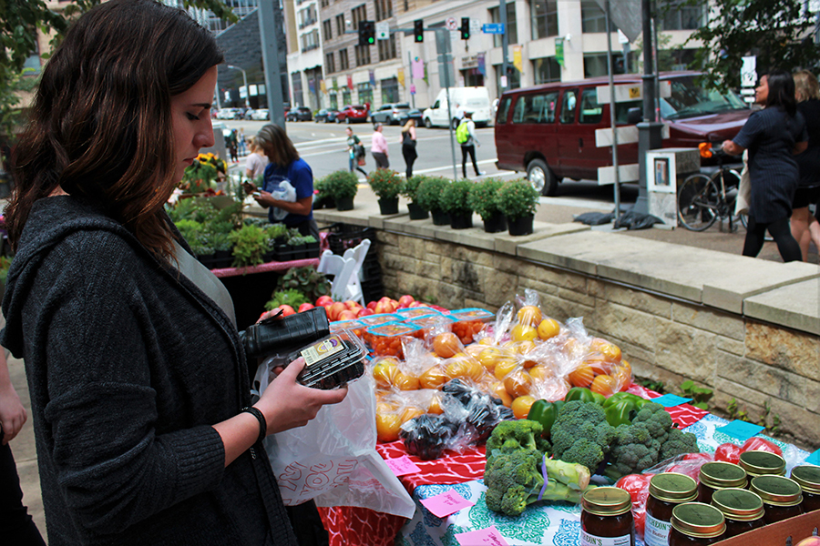 Jonnah McClintock, sophomore advertising and public relations major, selects blackberries from the Green Market table during the Farmer’s Market last week.