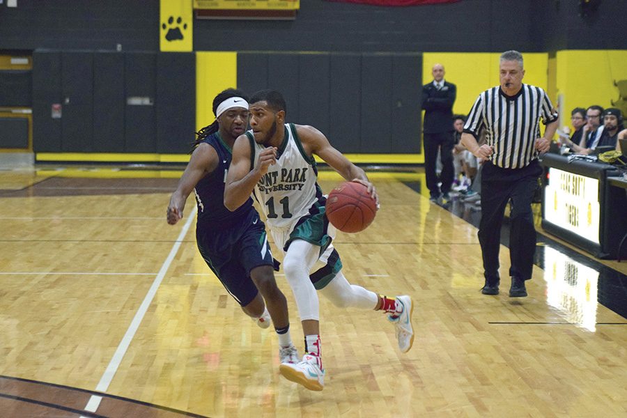 Senior point guard Gavin Rajahpillay drives the ball up the court past an opposing guard during a game against Villa Maria last year.
