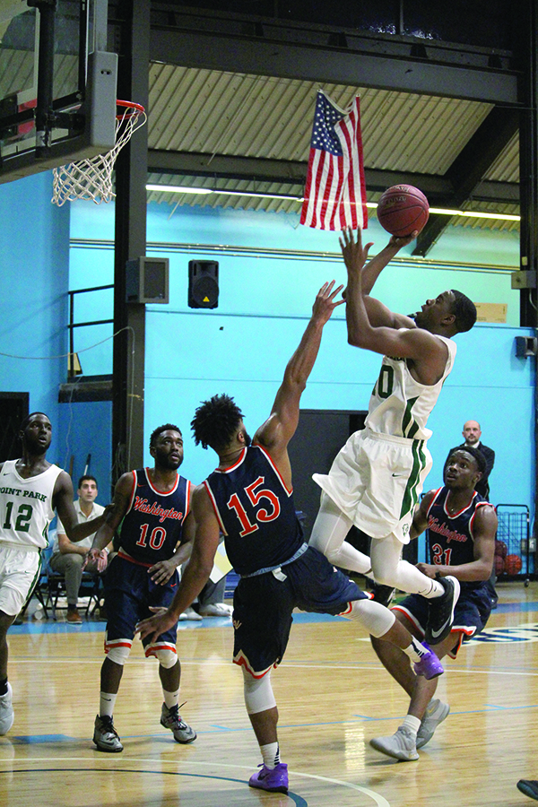 Senior forward Fousseini Konate shoots for a layup against Washington Adventist in Point Park’s home opener Nov. 22. Konate scored the team-high of 22 points for the Pioneers.