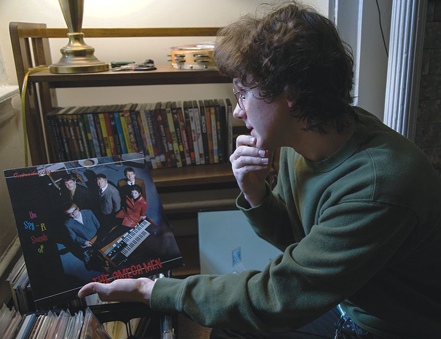 Alec Ebeling talks about a record from their father Eric Ebeling’s band in their Oakland home on Nov. 17.
