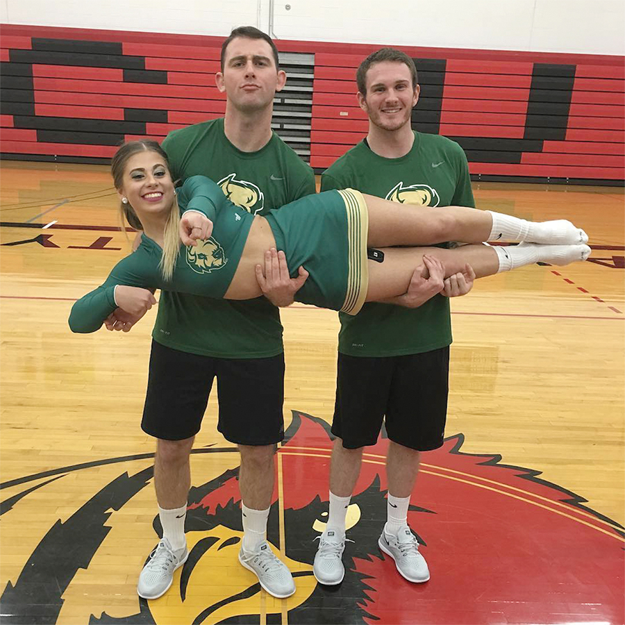 Cheer team members Benjamin Hawkins (Left), Kenny Sickles (Right) and Emily Kirsch pose for a photo after the Concordia Dual Competition on Dec. 9.