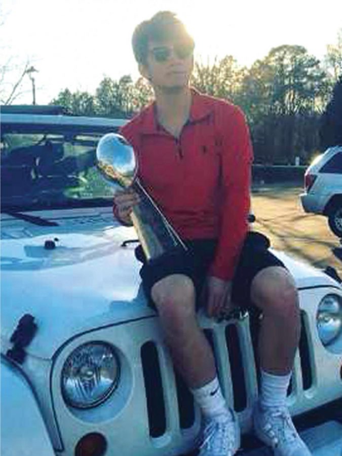 Ree poses on his Jeep holding the Lombardi trophy, which is given to the Super Bowl Champions.