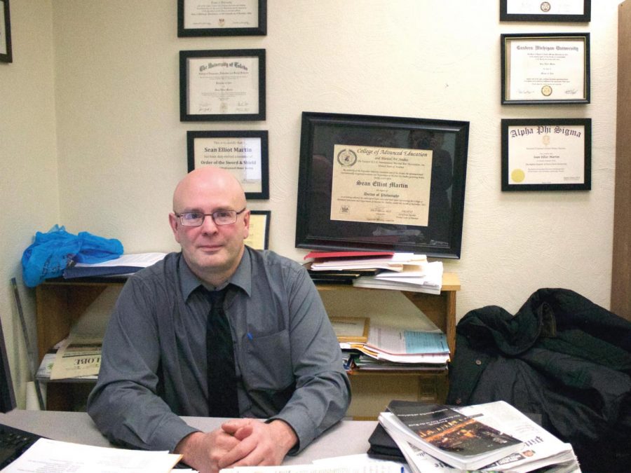 Dr. Martin, pictured here in his office, sits surrounded by his various degrees and awards.