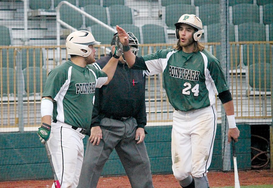 Seniors Richard Perez and Andres Herrera celebrate at home plate in a game last year. The Pioneers have won 14-straight games.
