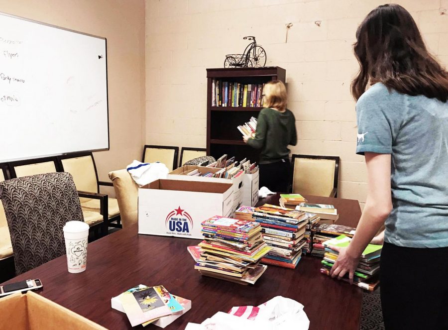Freshman honors students Madison Kelkis and Angela Runsack organize books for local organization A Giving Heart as part of Pioneer Community Day, which took place this Saturday. 