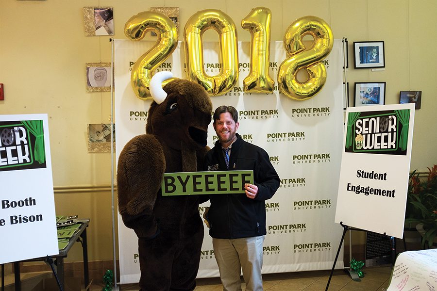 Michael Gieseke, Dean of Student Life, posing with Black Diamond II the Bison during the Senior Week Kick-Off in the Lawrence Hall Lobby on April 9, 2018.