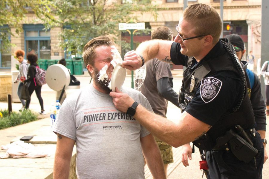 Point Park police officer Joe Shutka pies Alston Berkman at the Rugby Club’s second annual Pie-a-Rugger event. 