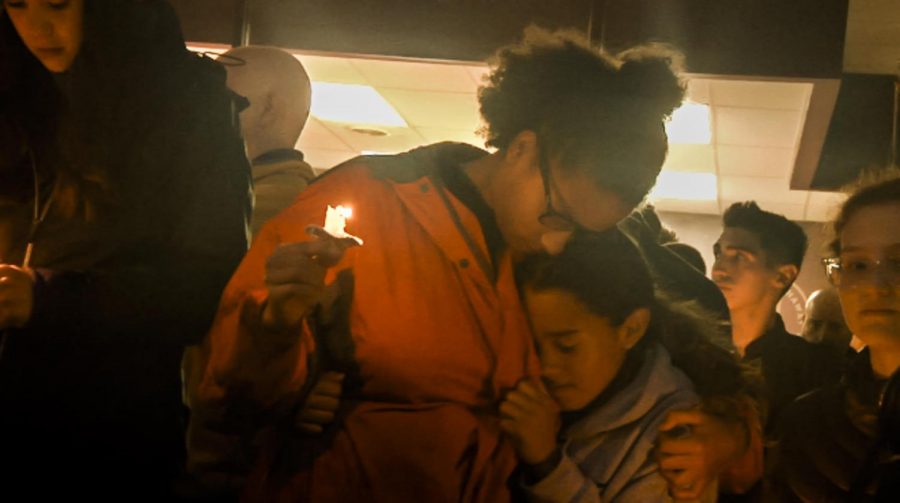 Isabel Smith exchanges an embrace during the vigil for the victims of the Tree of Life shooting Saturday night. Smith, alongside other high school students, organized the impromptu vigil.  
