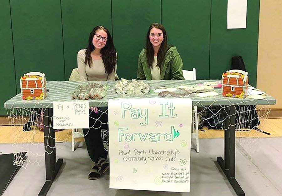 Pay It Forward’s Treasurer Nicole Lakovic (left) and President Jillian Svonavec (right) run a table at the Spring 2018 Condom Carnival. Pay It Forward is one of a number of charitable campus clubs.