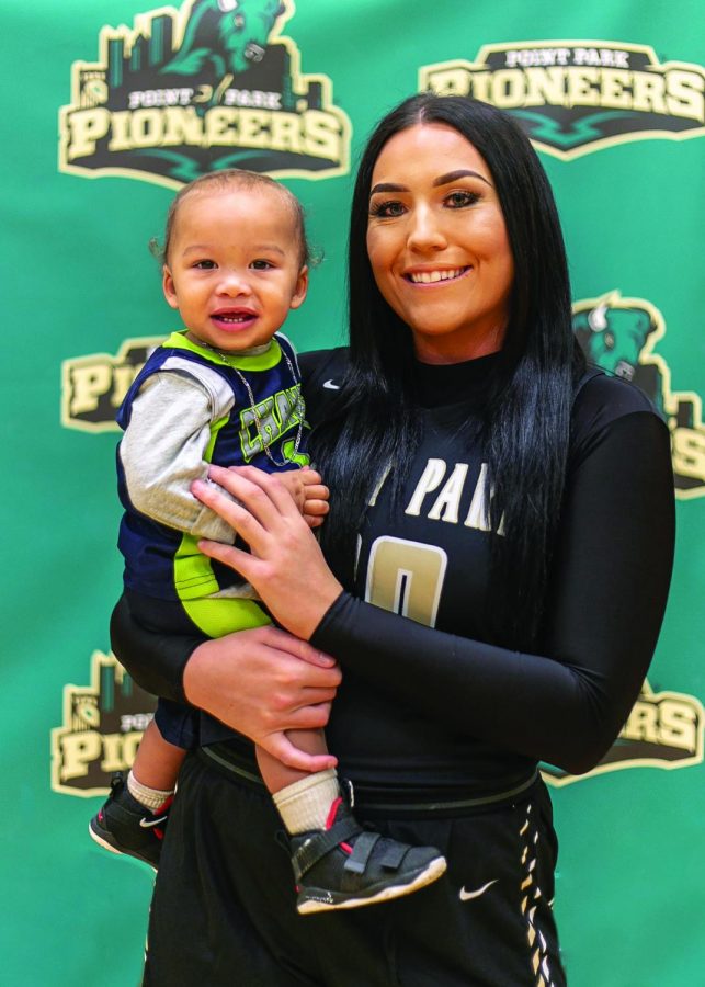 Senior Sam Weir poses during team photos with her baby boy, M.J.