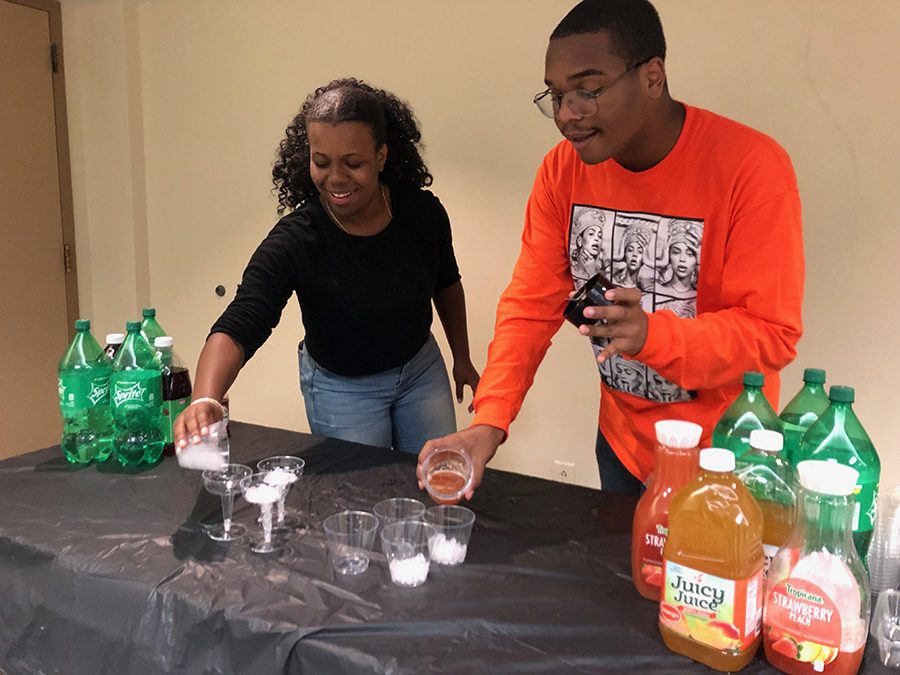 BSU members Divine Kennedy and Michael Moran hand out drinks at mixer event in the Lawrence Hall fourth  oor lounge on Sept. 3