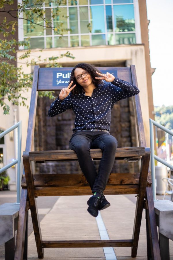 Marcyssa Brown, a senior SAEM major, sits on top of VistPittsburgh’s 8-foot-tall chair at Village Park. VisitPittsburgh’s Pull Up a Chair intiative came to campus last Wednesday. 