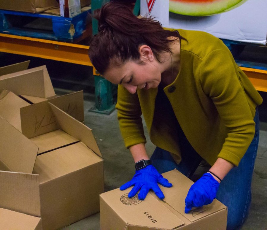 Jordyn Hronec | The Globe
Professor of Public Relations, Jenna Lo Castro, boxes up food at the Capital Area Food Bank during a community service project conducted by students on the annual Washington D.C. trip.