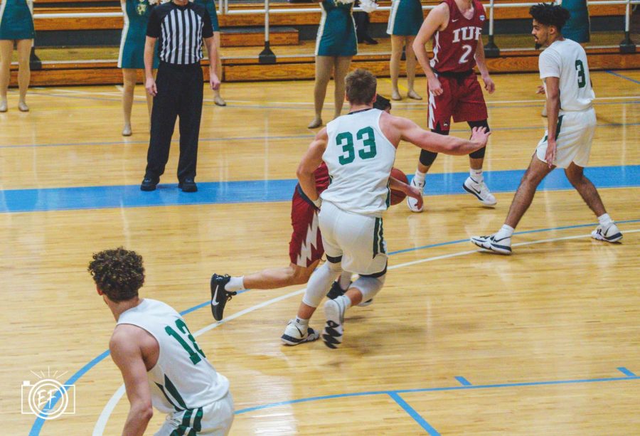 Junior forward Garret McHenry (33) closely defends an IU East guard in a game earlier this season. The transfer from Butler County Community College averages 5.1 rebounds per game and 12 points per game in 15 games played so far this season.