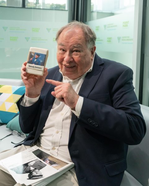 David Newell, aka Mr. McFeely, poses with a cookie with his character on it in the Center for Media Innovation, where he held a meet and greet with students last Monday, Oct. 9.