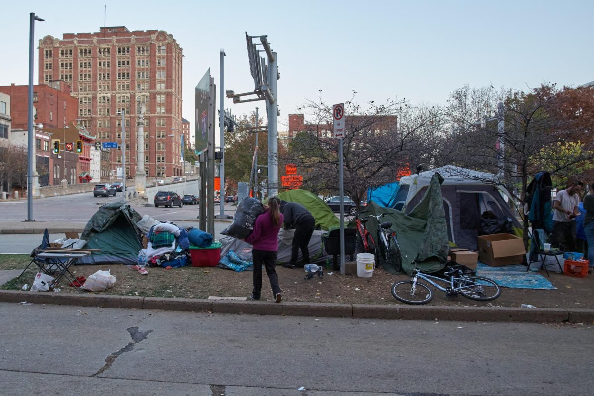 Volunteers help individuals at the encampment location on First Avenue and Grant Street move their items after the city issued the clearing of the site last week.