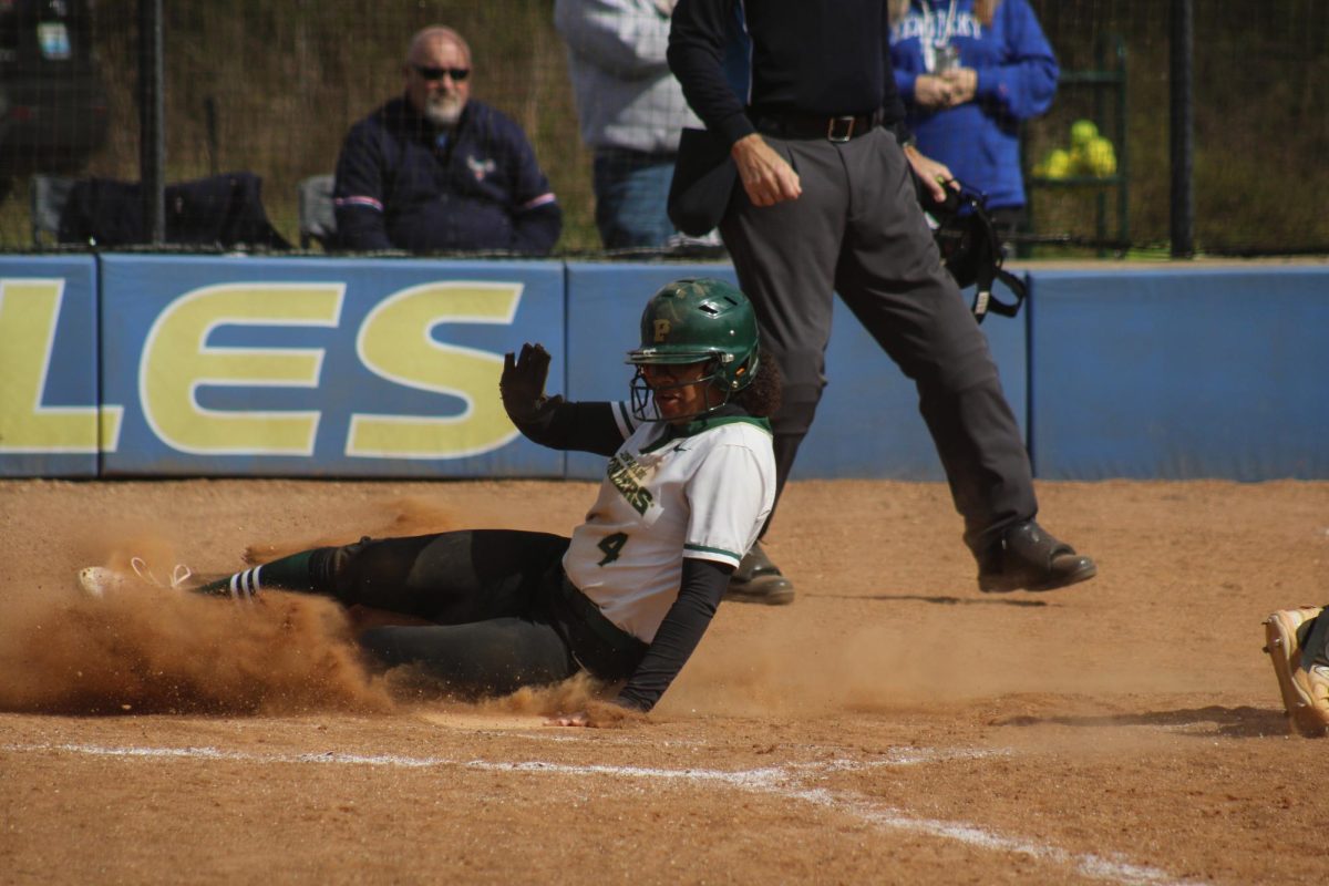 Senior outfielder Mackenzie Moore sliding home after a costly error from Midway.