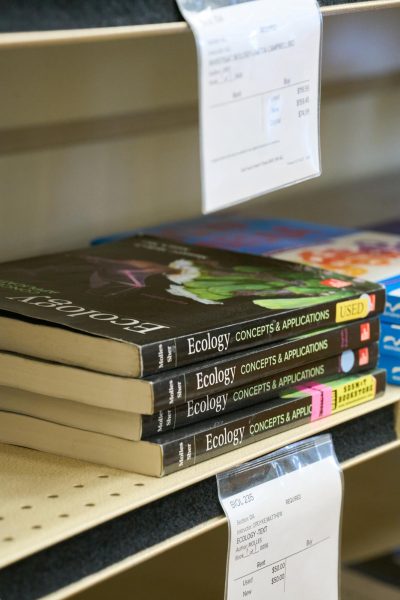 Four Ecology textbooks on a bookshelf next to three other college textbooks. These may be obsolete soon.