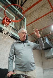 Scott Swain, now Vice President of Athletics, cuts down part of the net after the mens basketball team won the RSC championship title in early March.