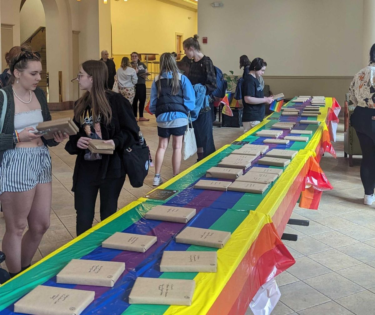 Students pick out covered books during a CAB Pride Week event in the Lawrence Hall lobby on Monday.