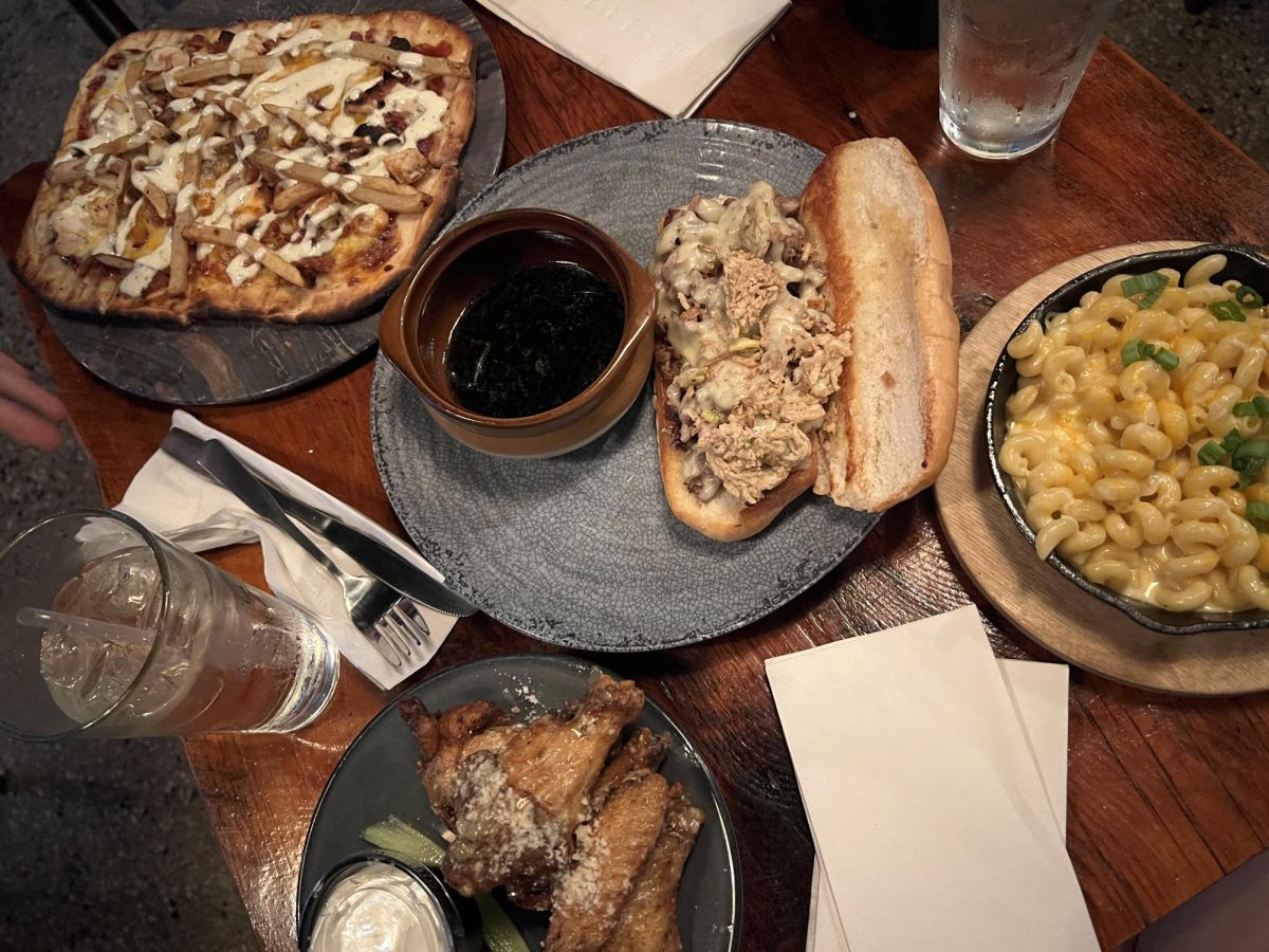 A table with the tavern dip (center), Pittsburgher (top right), mac and cheese (bottom) and wings (left) at the Forbes Tavern on Forbes Avenue.