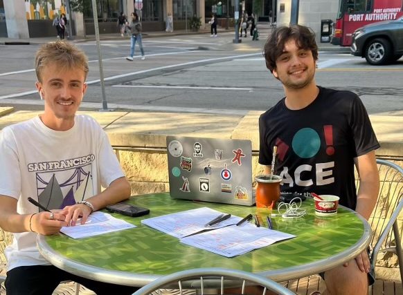 Jordan Kullen and Leandro Bilello-Rodriguez sit in Village Park to register new voters.