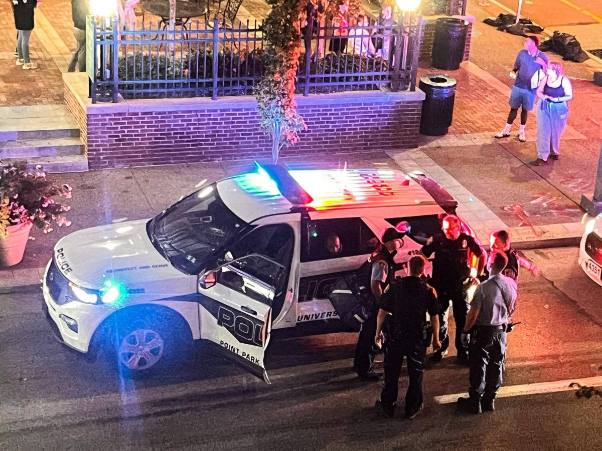 The suspect that harassed multiple students sits inside of a university police car outside of Thayer.