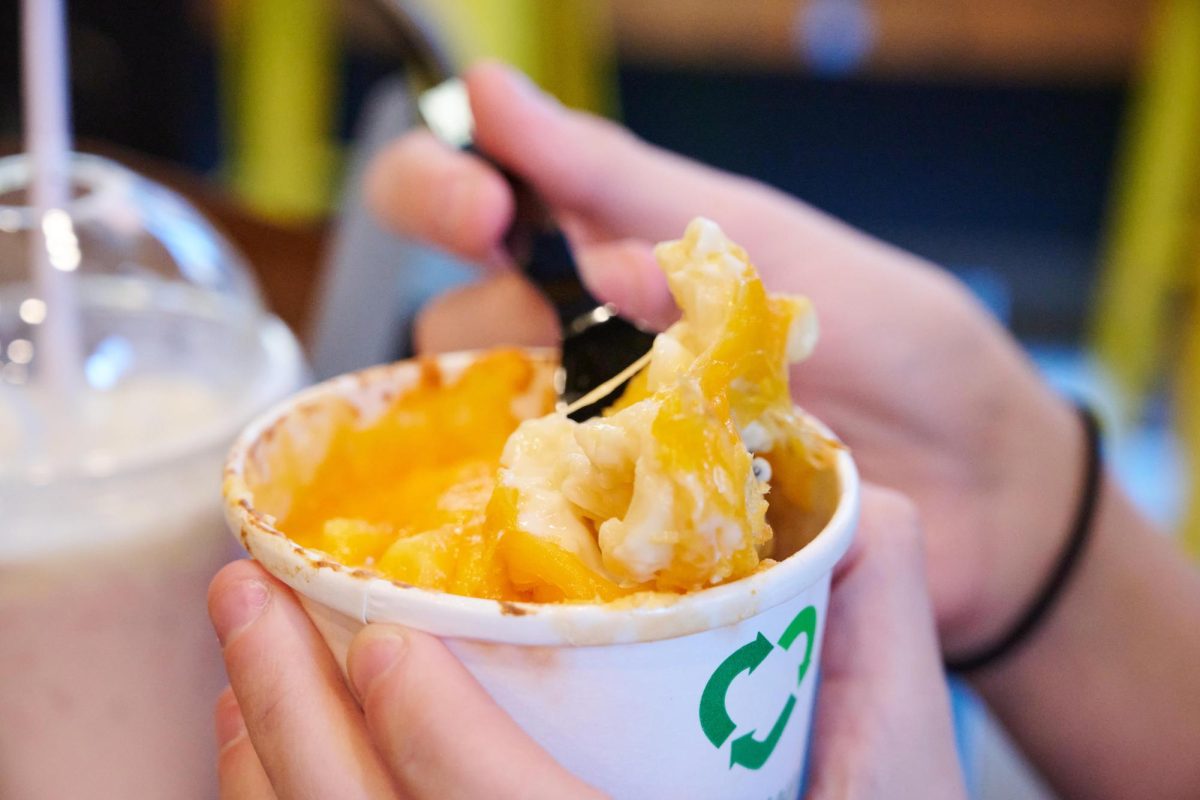 Noodles being pulled out of a cup of mac and cheese from the BERG, which had a thick layer of cheese on top. 