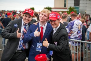 Young Trump supporters pose for a photo in front of the line to the rally.