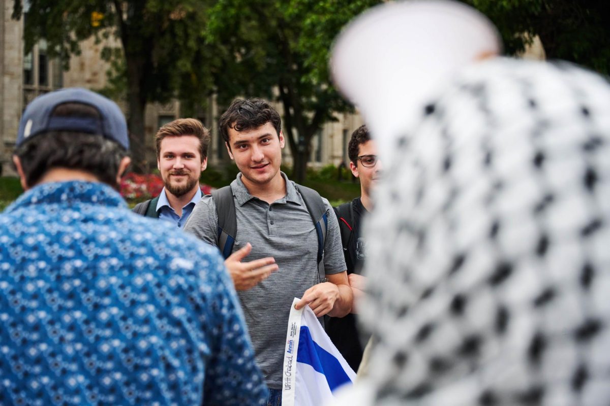 Pro-Israel counter-protestors stand outside and talk with Pro-Gaza protesters at Pitt. 