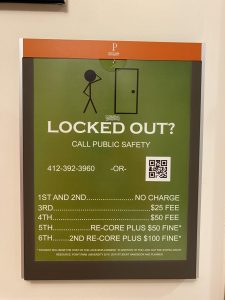 A sign in Boulevard Apartments explaining the policy that charges students a $100 fine plus a re-core after the sixth lockout. 