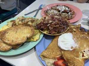 (Left to right) The broccoli and cheddar omelet, croissant french toast, corned beef hash and strawberry hotcakes sit on a table at the diner.