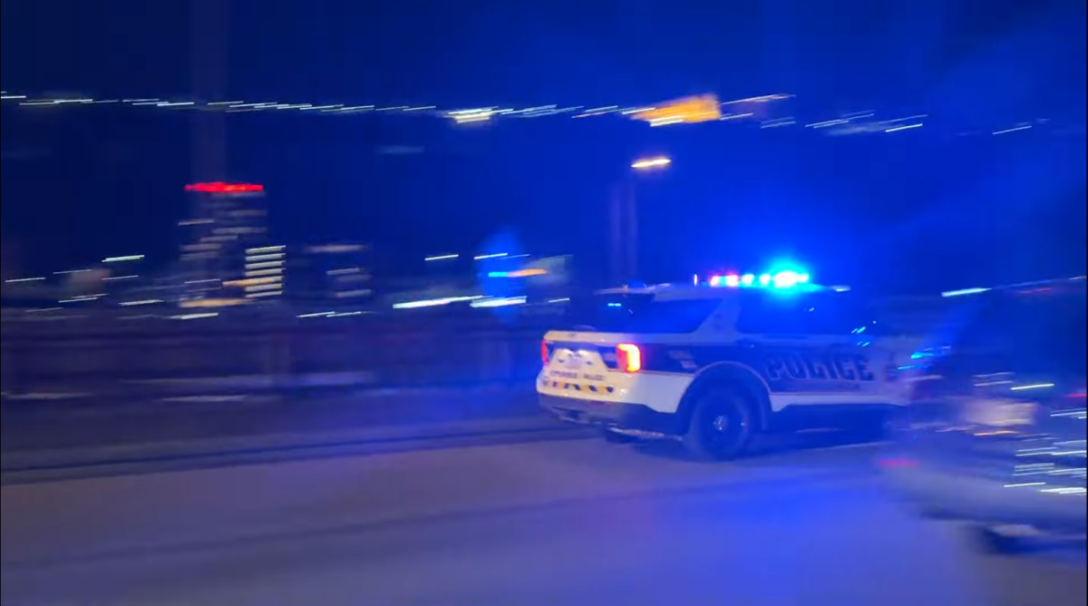 A Pittsburgh police car quickly passes by Conestoga Hall.