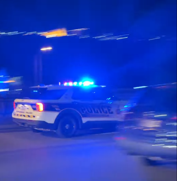 A Pittsburgh police car quickly passes by Conestoga Hall.