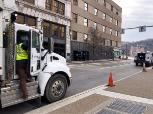 A Peoples Gas truck sits on Wood Street in front of West Penn with workers going in and out of the vehicle. 