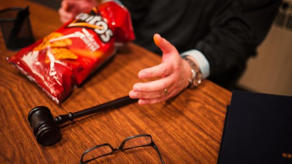 The judge, played by Denny DiPalma, shows his fingers covered in Doritos dust for the "Crash the Super Bowl" ad submitted by the two students. 

Submitted by Nihad Hebib and Shandon Walsh