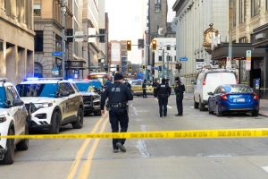 Pittsburgh police walk along the crime scene of the shooting.