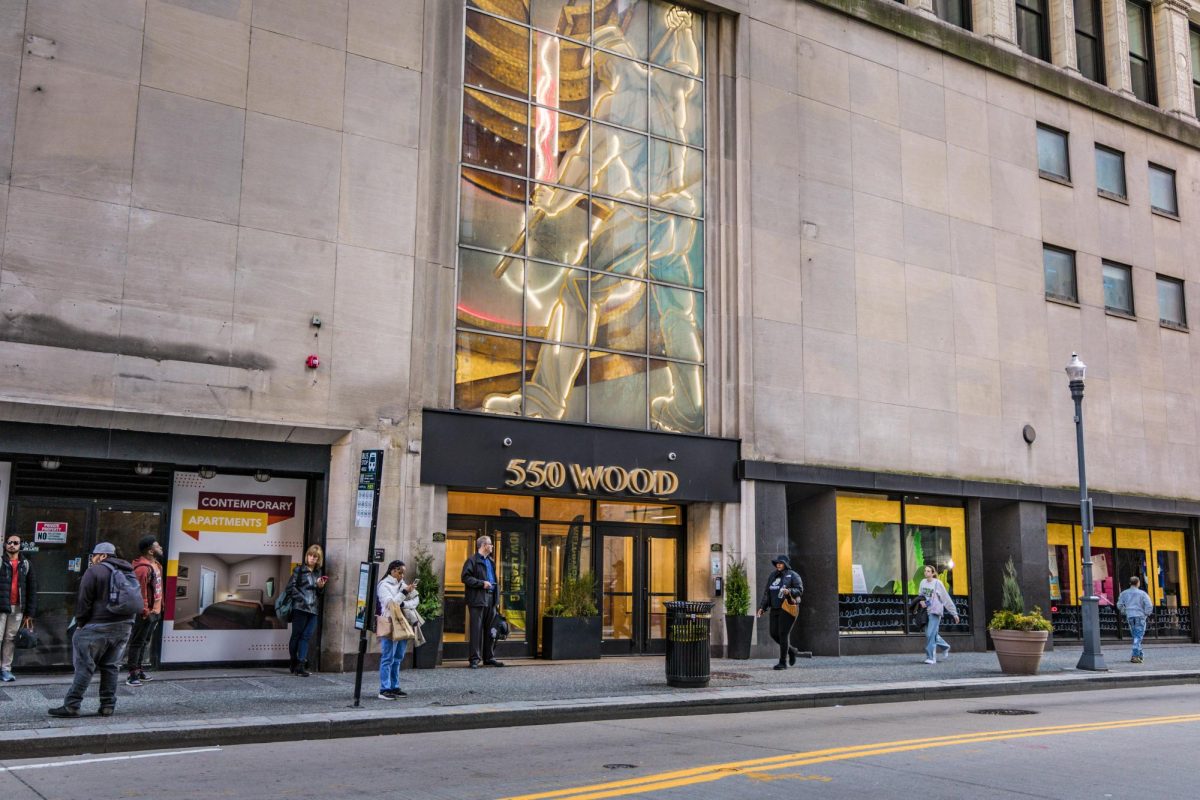 The exterior of the new LiveWell Apartments in the former GNC Headquarters on the corner of Wood Street and Sixth Avenue features an art installation named "The Puddler."